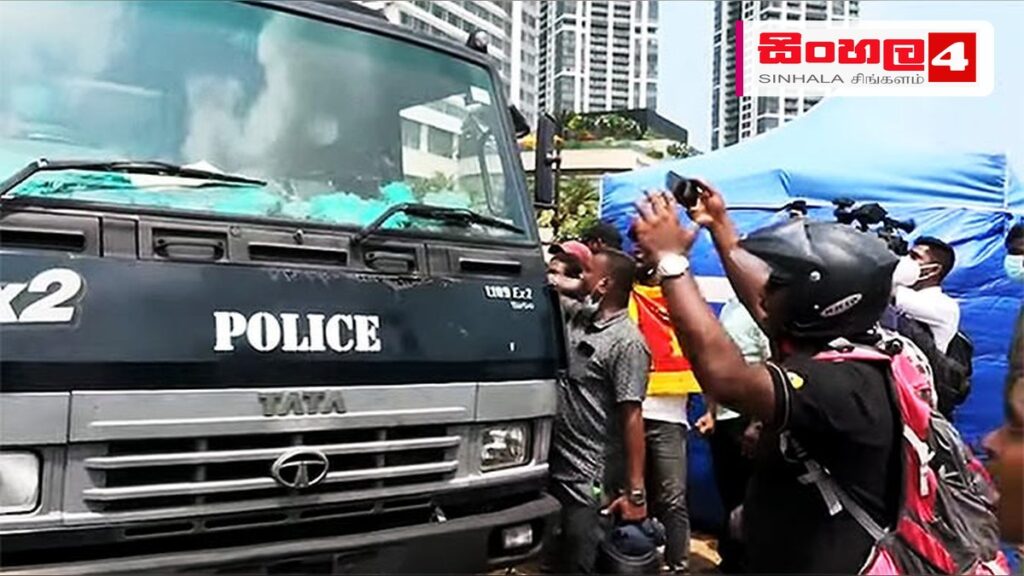 වන් ගෝල් ෆේස් දොරටුව අසලදී පුද්ගලයින් දෙදෙනෙකු අත්අඩංගුවට Headline: වන් ගෝල් ෆේස් දොරටුව අසලදී පුද්ගලයින් දෙදෙනෙකු අත්අඩංගුවට Intended image subject: Police officers inspecting a vehicle near Galle Face Story summary: කොළඹ වන් ගෝල් ෆේස් ස
